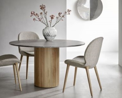 Runder Esstisch mit grauer Tischplatte und Holzfuß, umgeben von gepolsterten Stühlen. Modernes Esszimmer-Set.