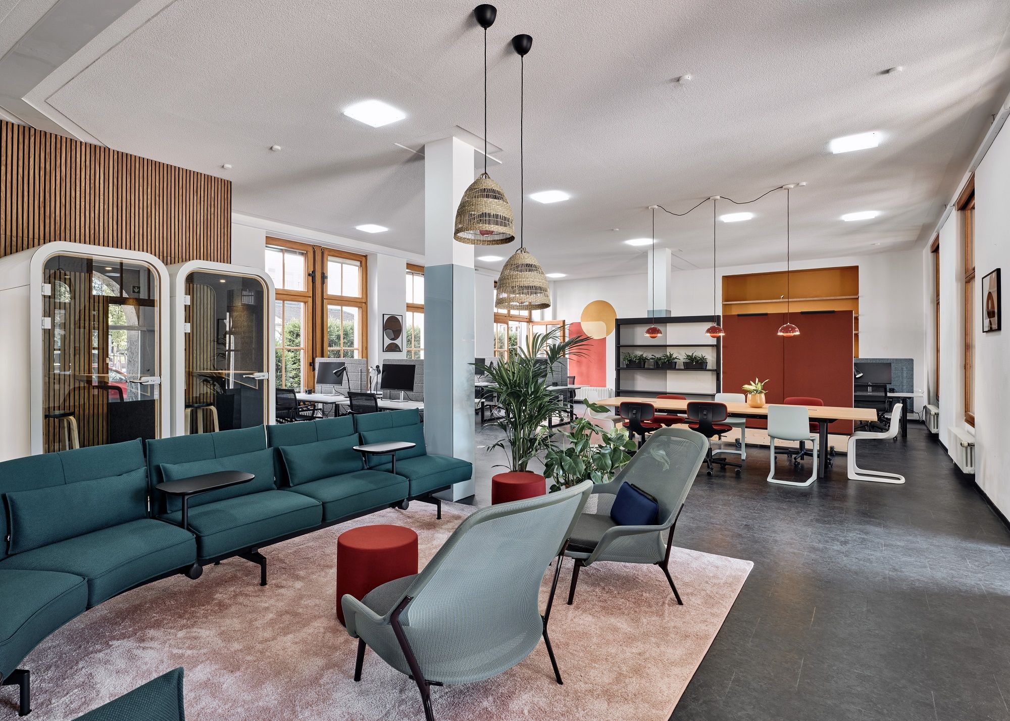 Vitra Slow Chair Sessel in modernem Büro-Lounge-Bereich mit grünen Sofas und stilvoller Büroeinrichtung.