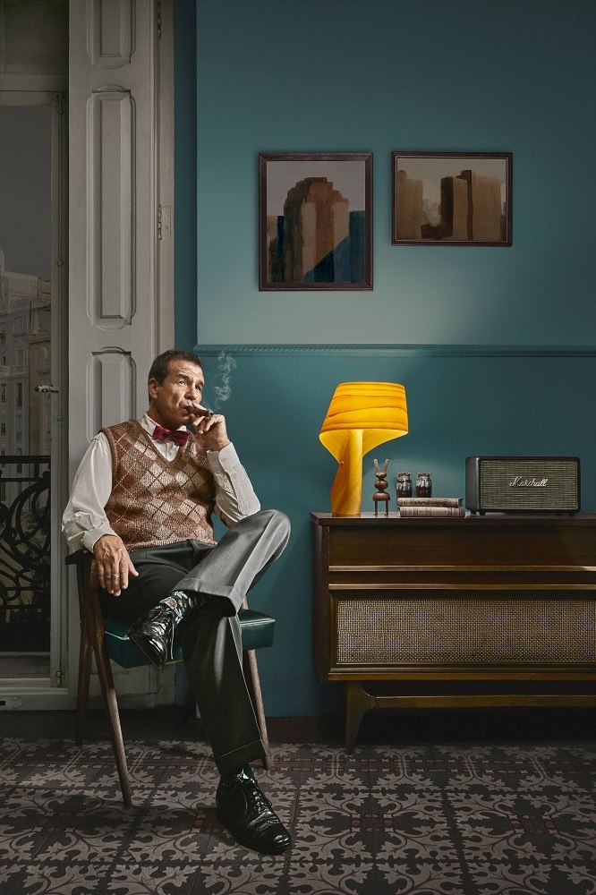Mann mit Zigarre neben gelber Air Tischleuchte von LZF Lamps auf einem Sideboard.
