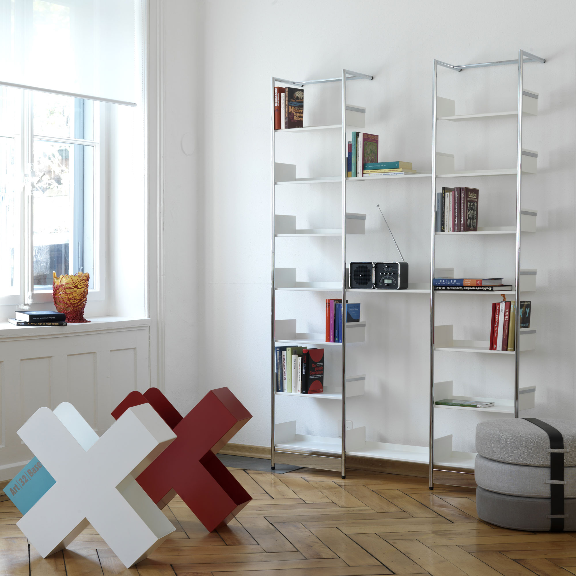 Pool 196 Medium Anlehnregal von Mox, modernes, weißes Bücherregal mit Chromgestell im Wohnzimmer.