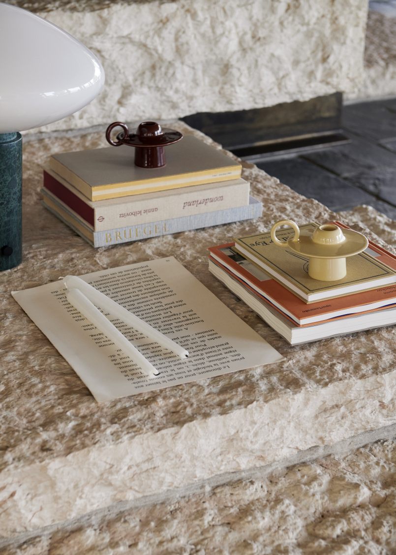Nahaufnahme der AndTradition Mist AP17 Tischleuchte Guatemale Verde, kombiniert mit Büchern und Kerzenhaltern.