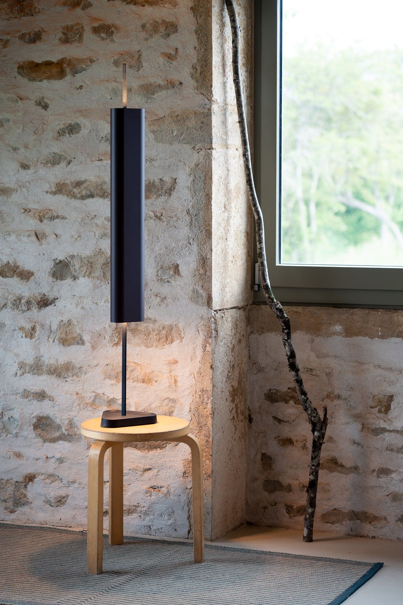 Emi Tischleuchte von Flos in Tiefrot auf einem Hocker, modernes Design.
