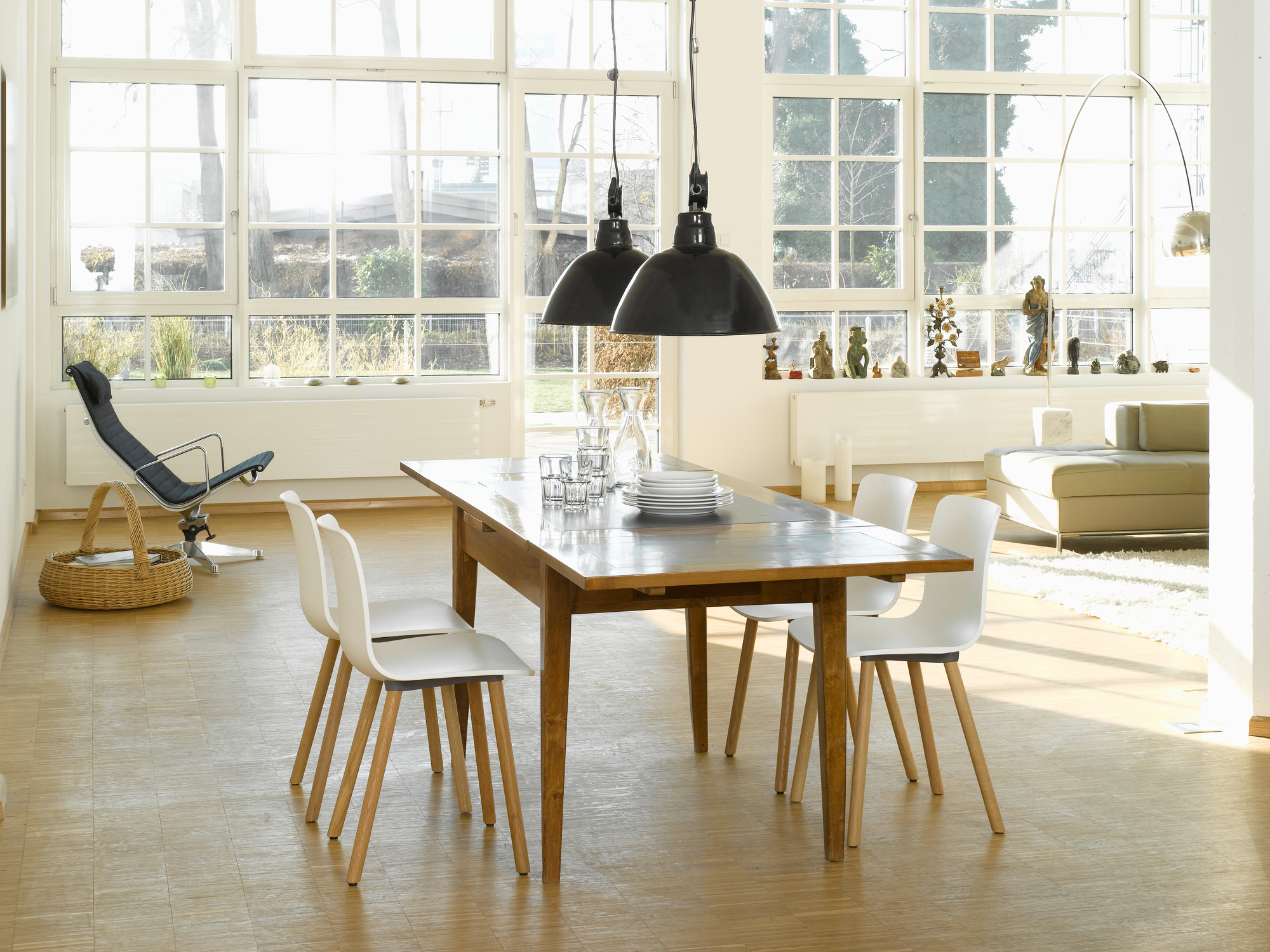 Esszimmer mit Holztisch, weißen Hal Ply Wood Stühlen von Vitra und großen Fenstern.