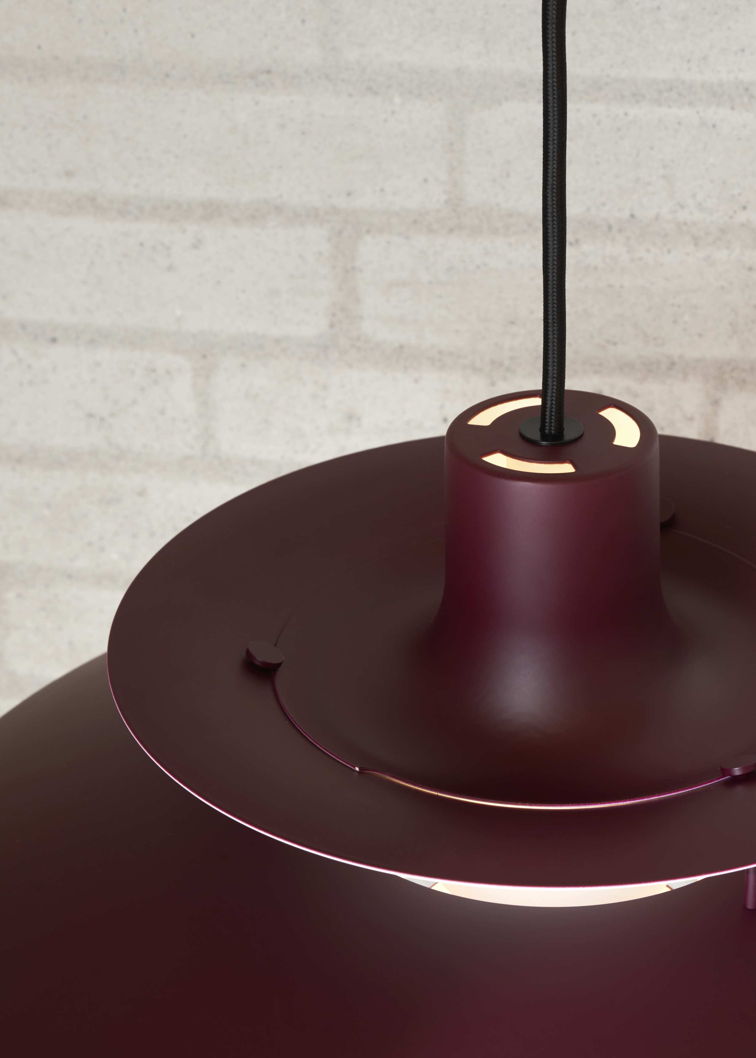 Detailaufnahme der burgunderroten PH 5 Pendelleuchte von Louis Poulsen, moderne Designerlampe für stilvolle Innenräume.