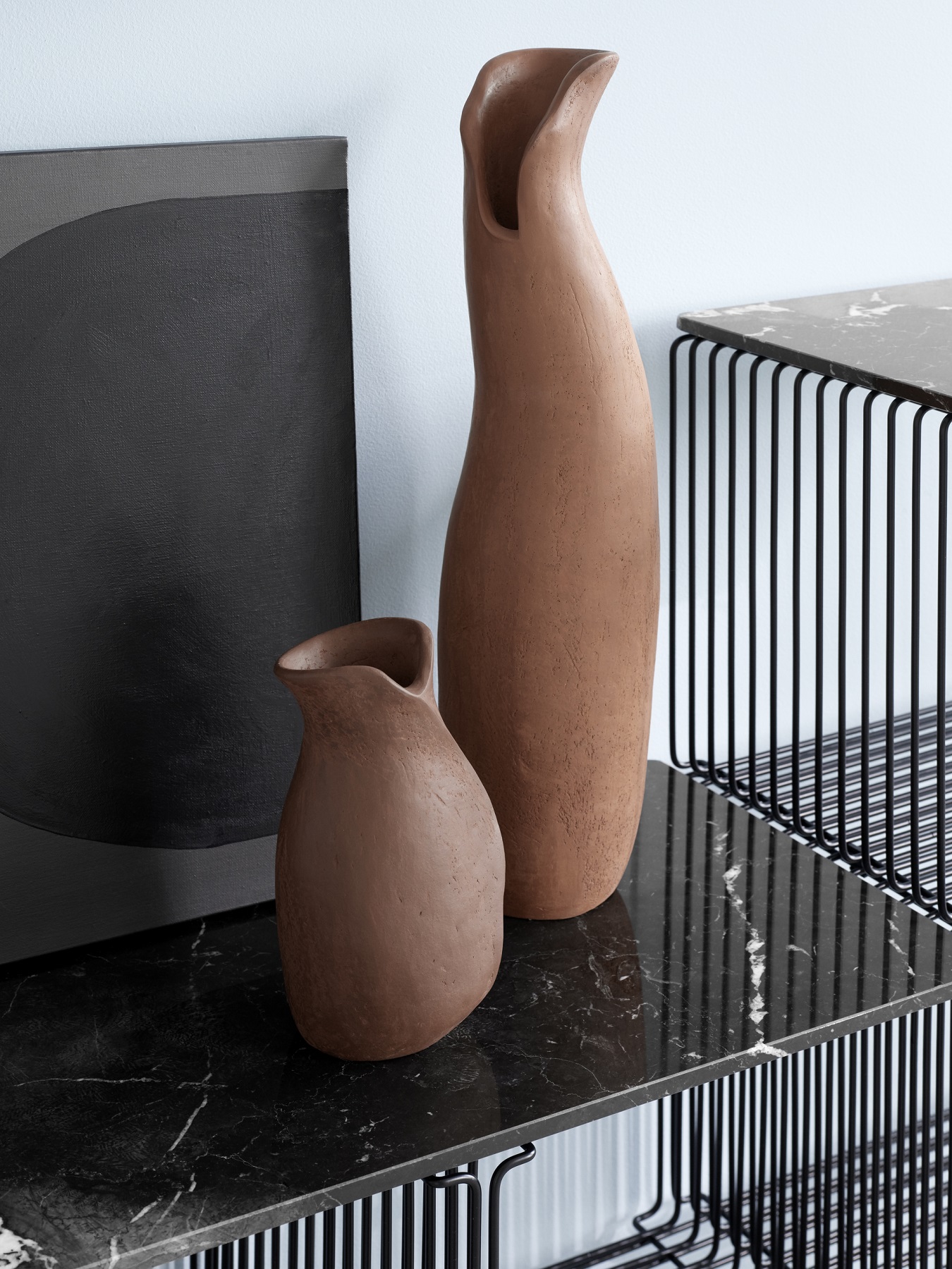 Panton Wire Regal mit zwei braunen Vasen und einem schwarzen Bild auf einer Marmorplatte.