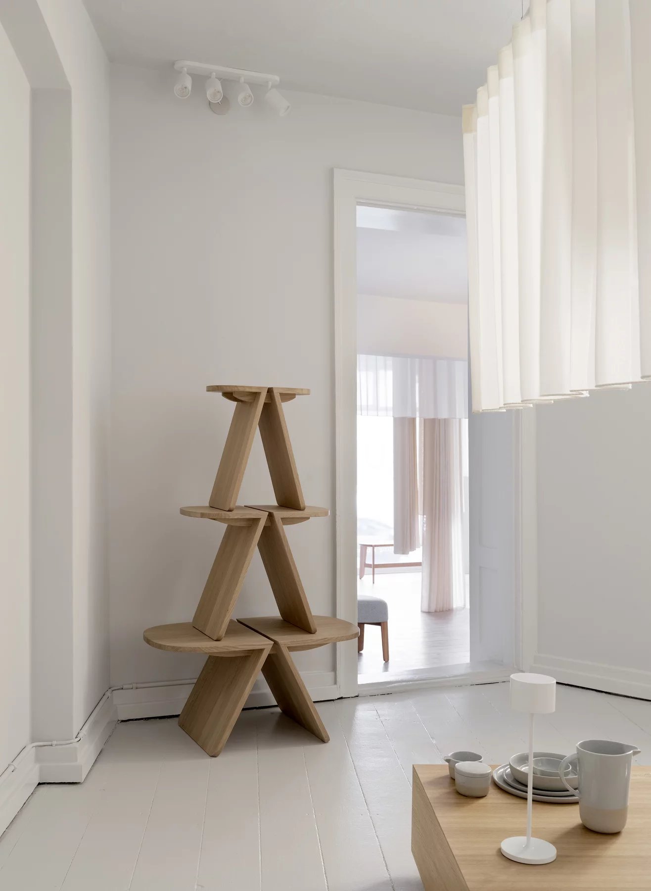 Blomus Goba Couchtisch aus Holz, quadratisch, mit Geschirr und Lampe in minimalistischem, hellem Raum.