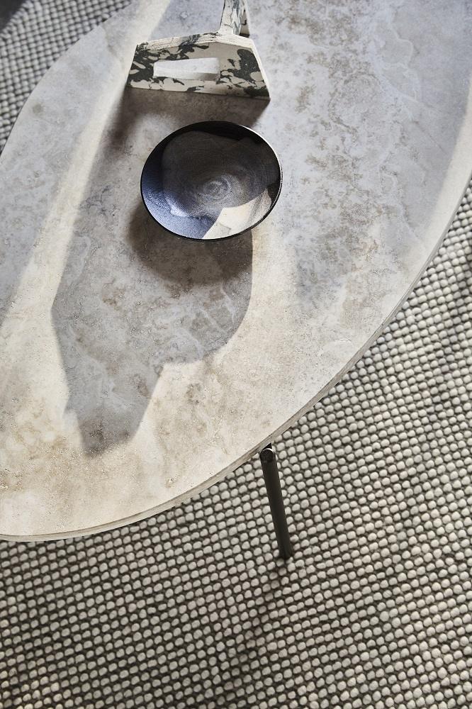 Nahaufnahme des La Terra Couchtischs von Woud, mit Schale und Dekoration auf der Steinoberfläche.