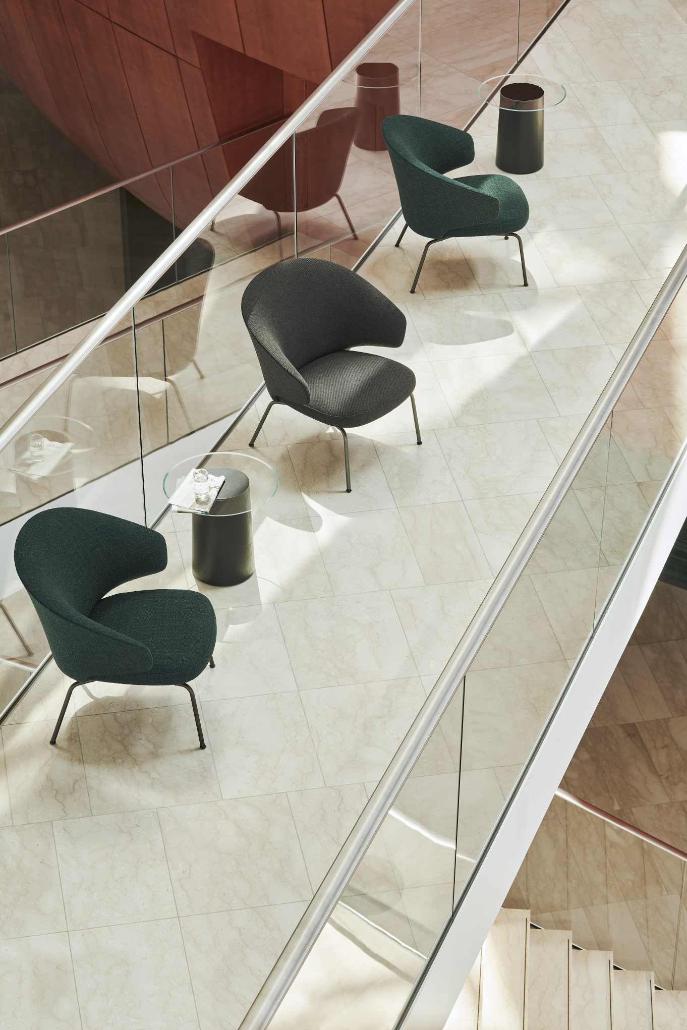 Fritz Hansen Let Sessel in Grau und Grün auf hellem Marmorboden, modernes Lounge-Mobiliar.