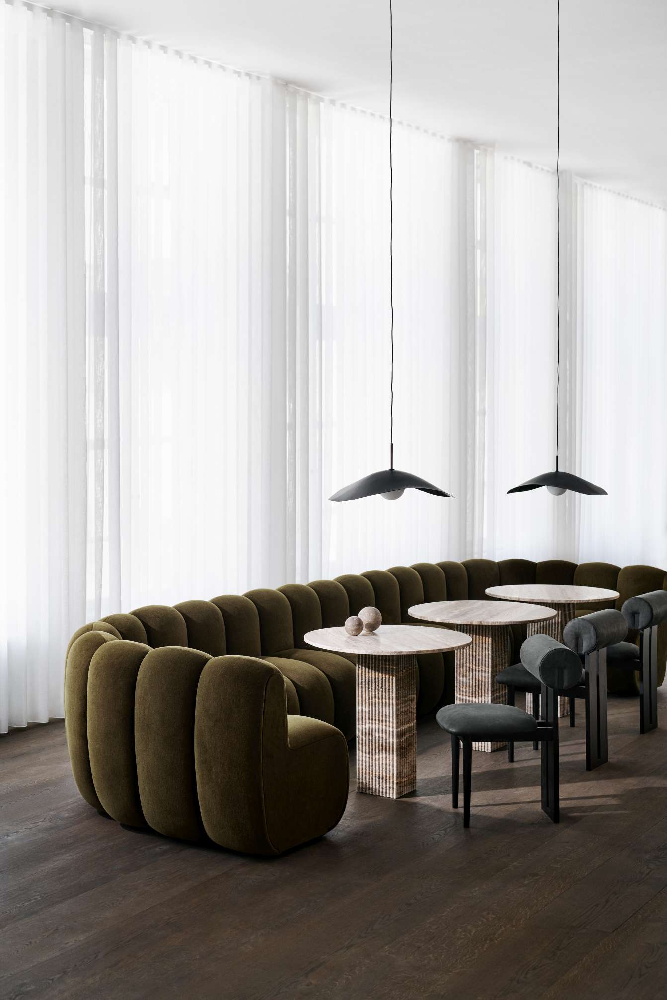 NORR11 Hippo Stuhl in Olivgrün mit runden Formen, kombiniert mit Tischen und Stühlen in modernem Ambiente.