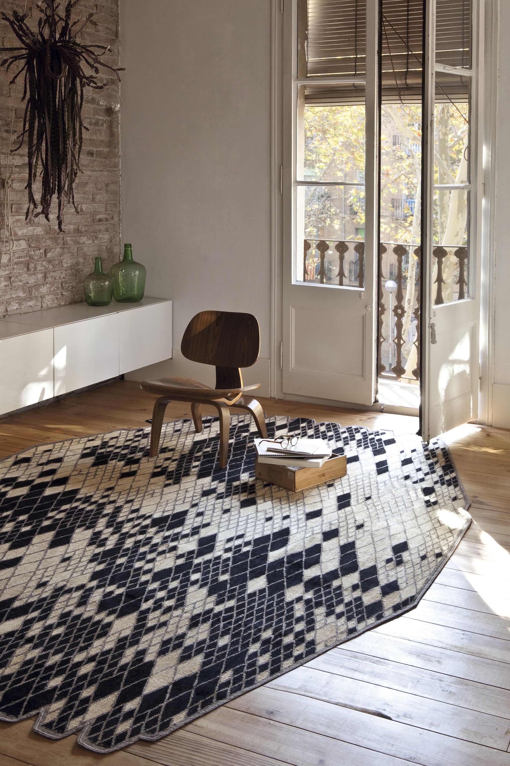 Nanimarquina Losanges Teppich mit Rautenmuster in Schwarz und Beige im hellen Wohnzimmer.