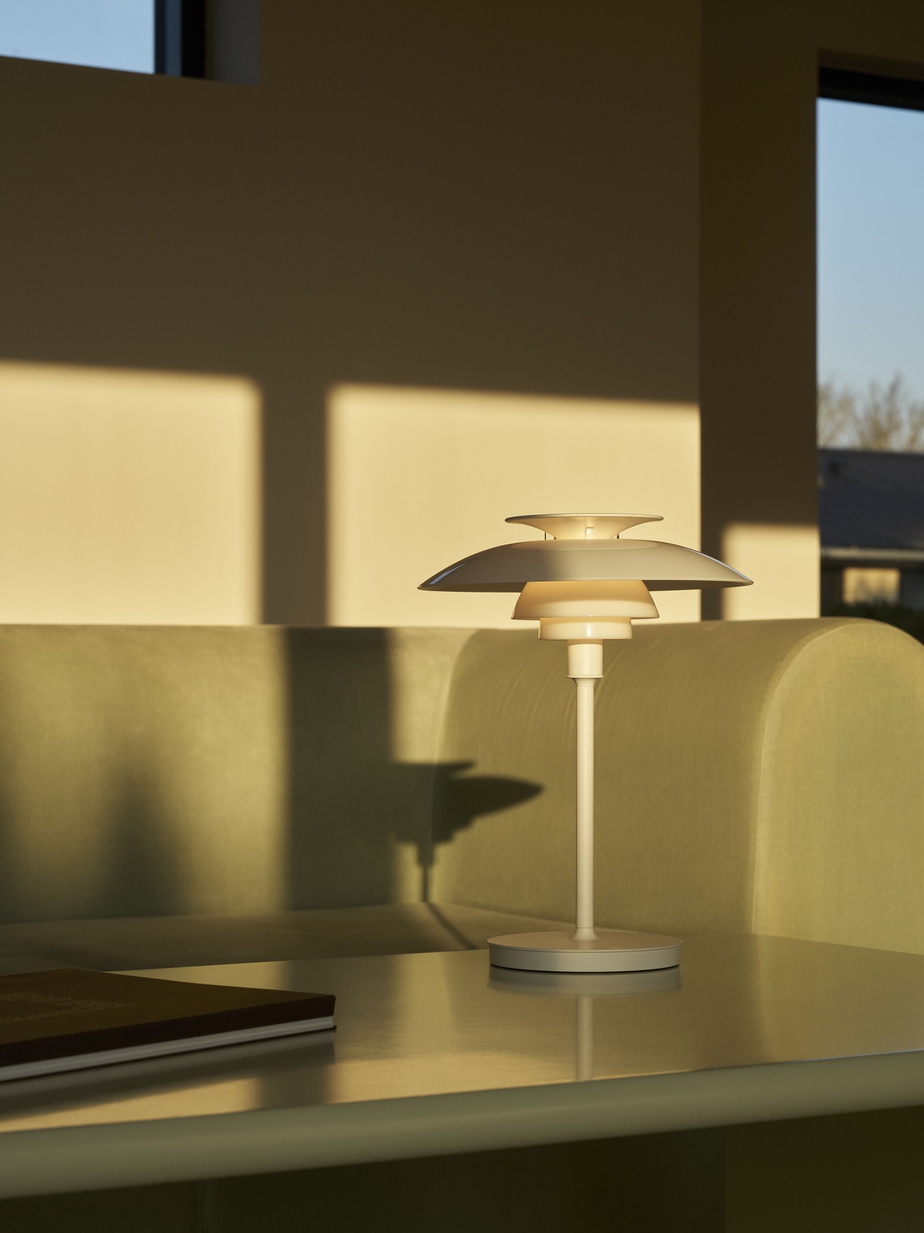 Weiße PH 80 Tischleuchte von Louis Poulsen auf einem Tisch, stimmungsvolles Licht.