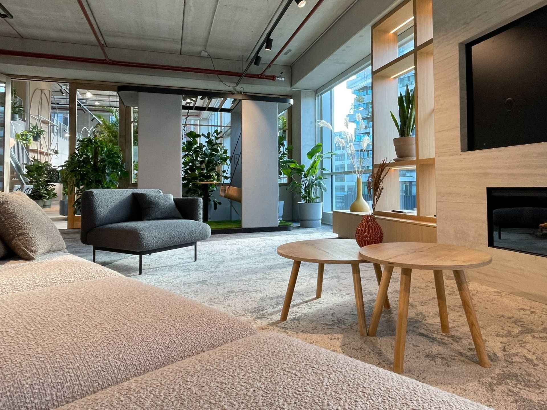 Grauer fora FR 401 Sessel von Bejot in modernem Büro-Lounge-Bereich mit Sofa und Beistelltischen.