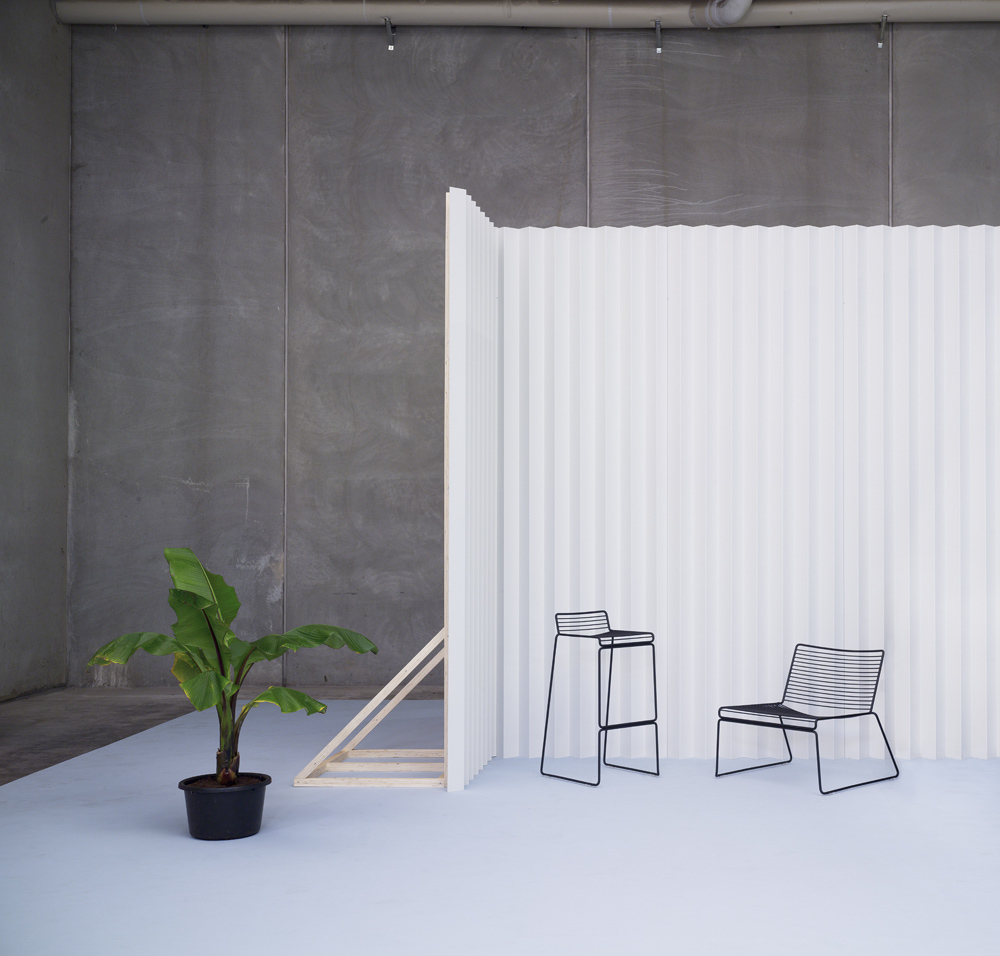 Minimalistisches Interieur mit Hee Dining Chair Stuhl Hay und Barhocker, schwarzes Drahtgestell vor weißem Hintergrund.