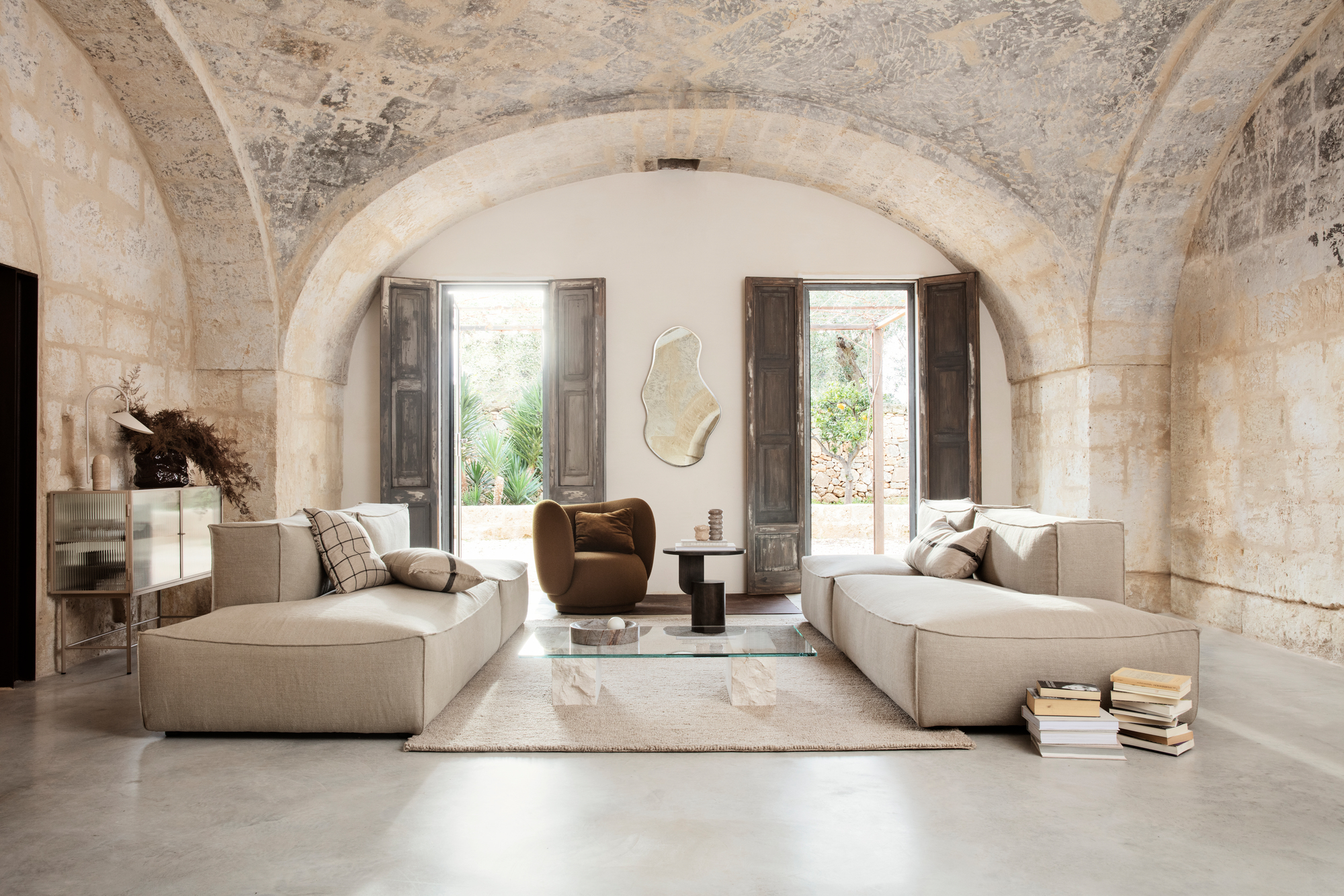Wohnzimmer mit Rico Lounge Chair Bouclé Sessel von Ferm Living und beigen Sofas.