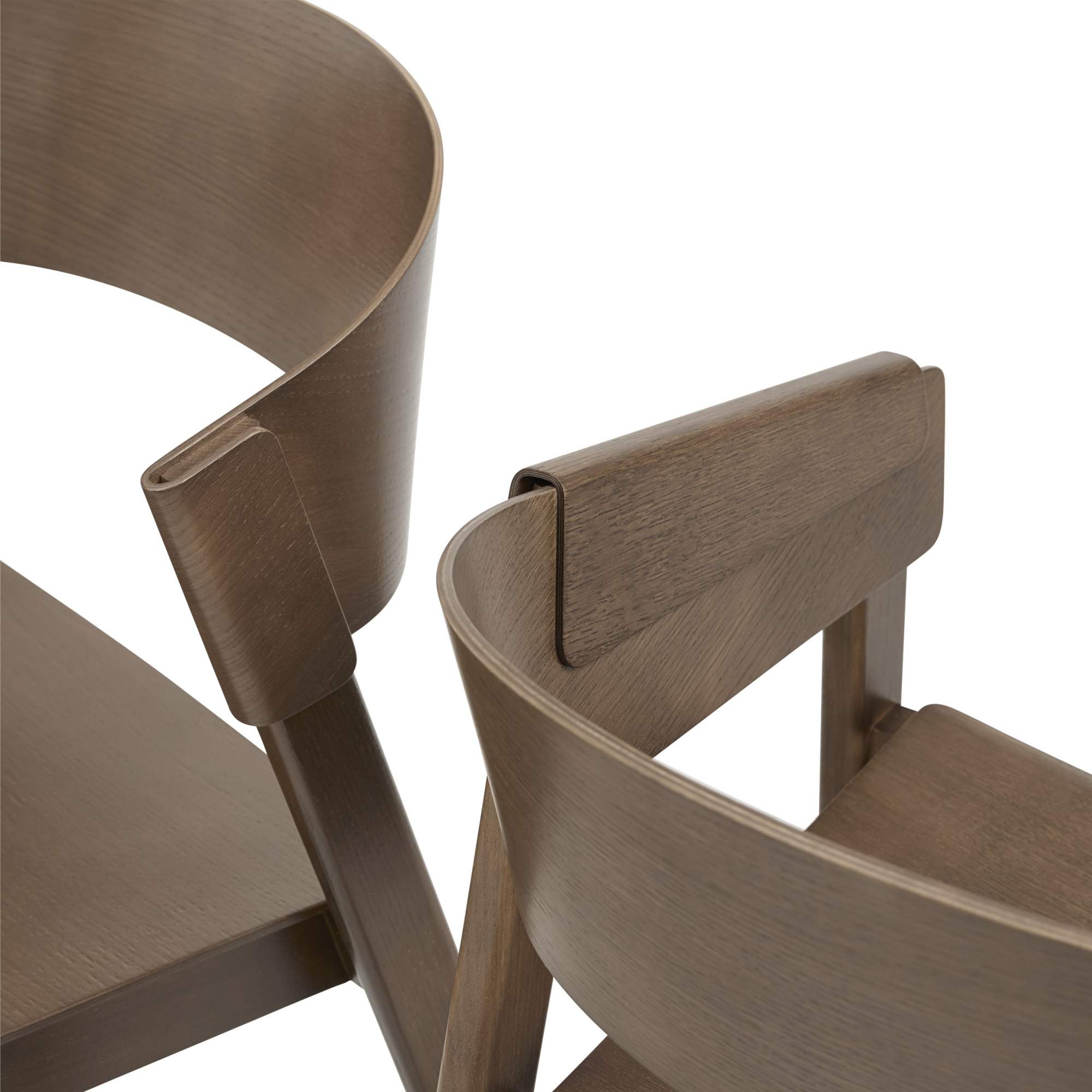 Detailaufnahme von zwei Cover Side Chairs von Muuto, Holzstühle mit geschwungenen Rückenlehnen in brauner Holzoptik.