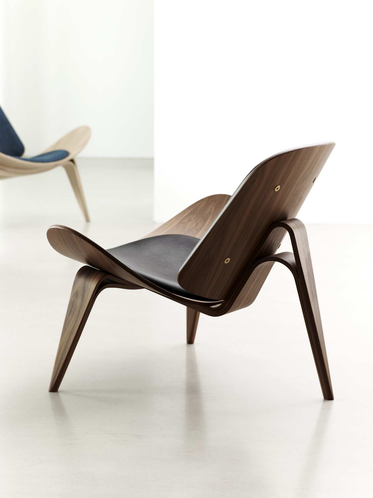 CH07 Shell Chair Stuhl von Carl Hansen in Walnuss mit schwarzem Lederbezug, seitliche Ansicht.