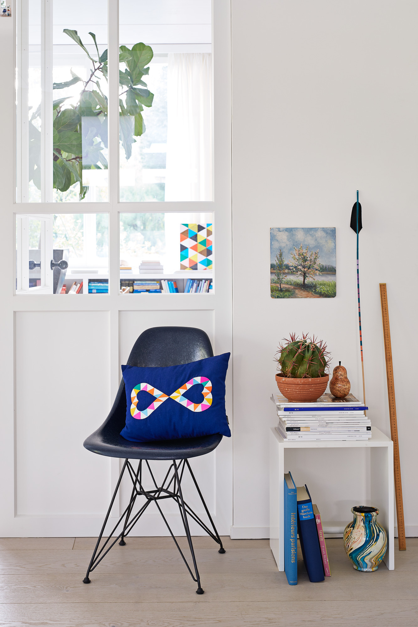 Blaues Kissen mit Herz-Stickerei auf einem Stuhl, Teil der Vitra Kissen Kollektion.