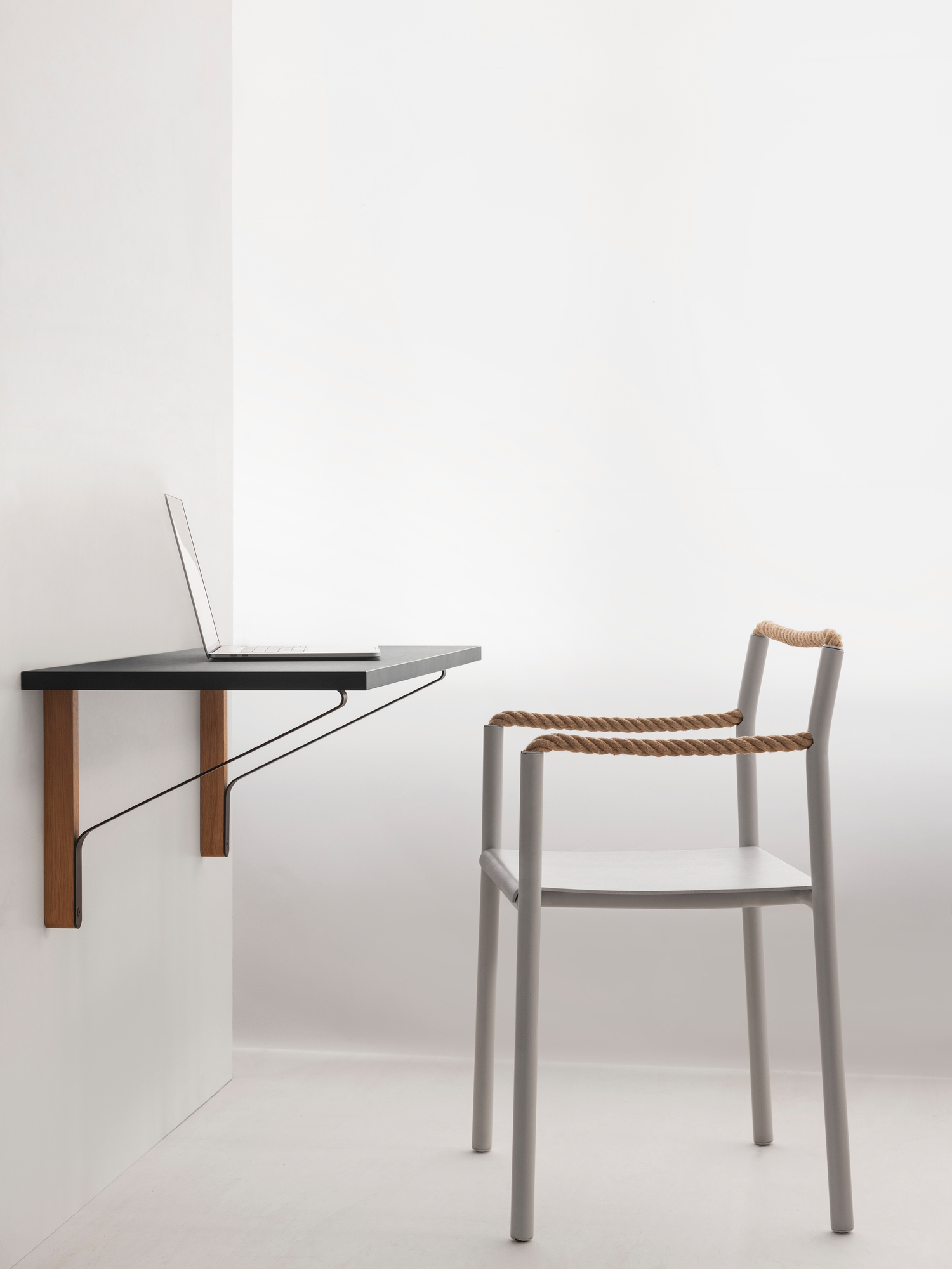 Artek Rope Chair Stuhl neben einem an der Wand montierten Schreibtisch mit Laptop in minimalistischem Raum.