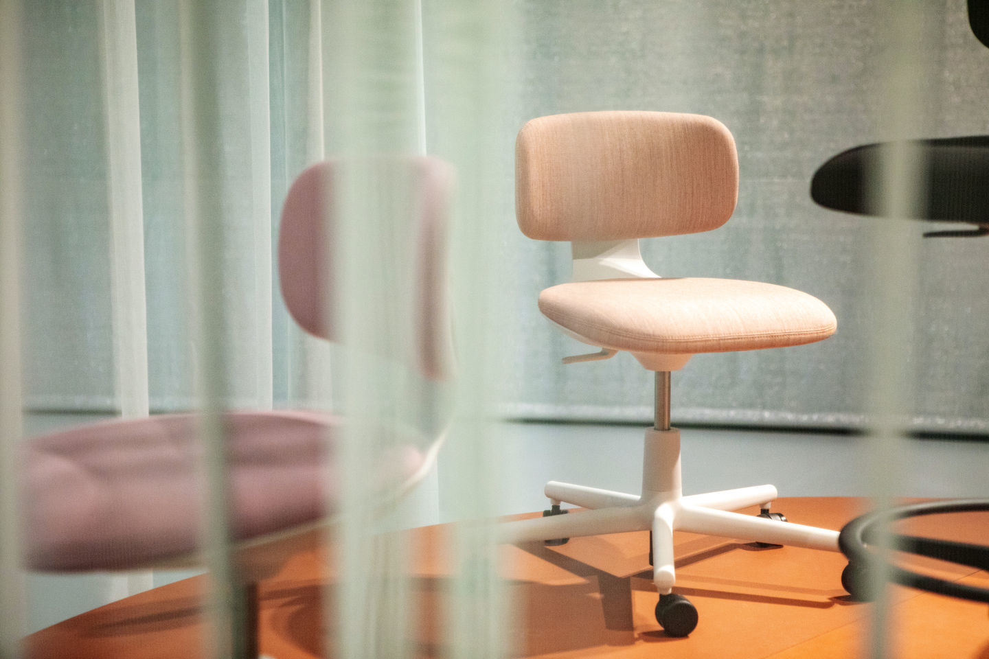 Beiger Vitra Rookie Bürodrehstuhl mit weißem Fußkreuz und Rollen, ideal für moderne Arbeitsplätze.