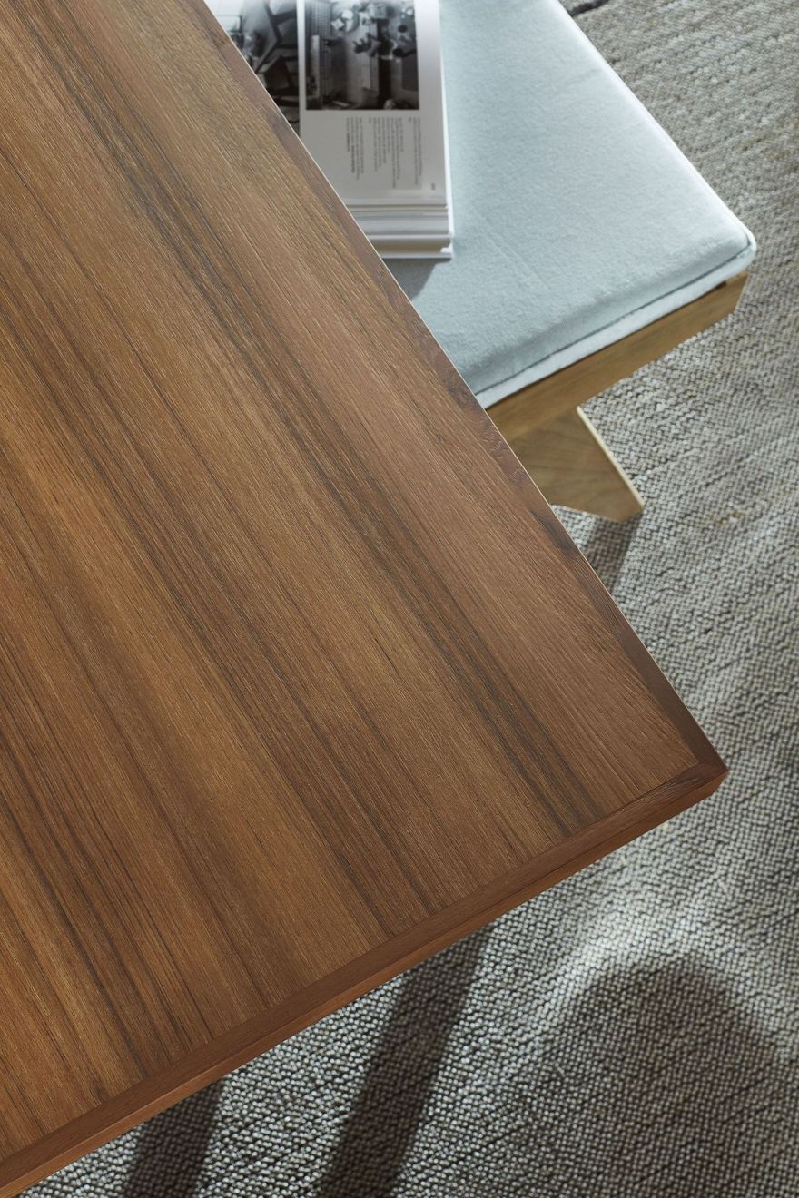 Detailaufnahme der Tischplatte des Cassina 056 Capitol Complex Tisches mit Holzfurnier und Buch.