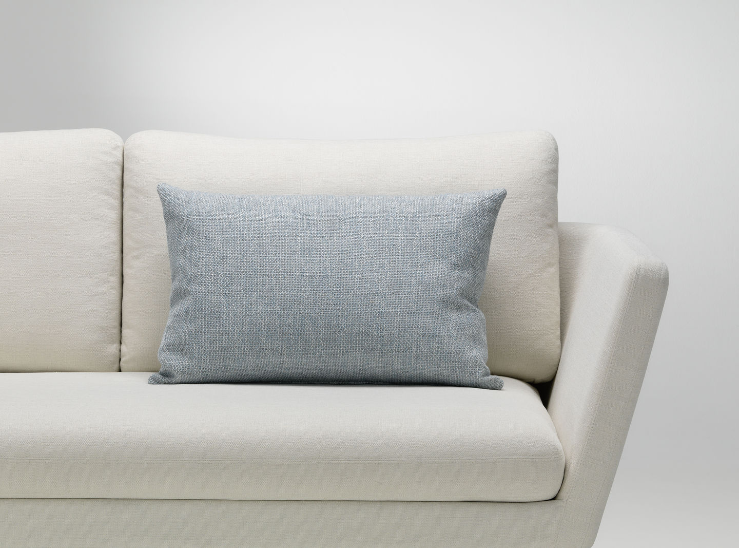 Vitra Kissen in Hellblau auf einem weißen Sofa, Dekokissen für Wohnzimmer und Schlafzimmer.