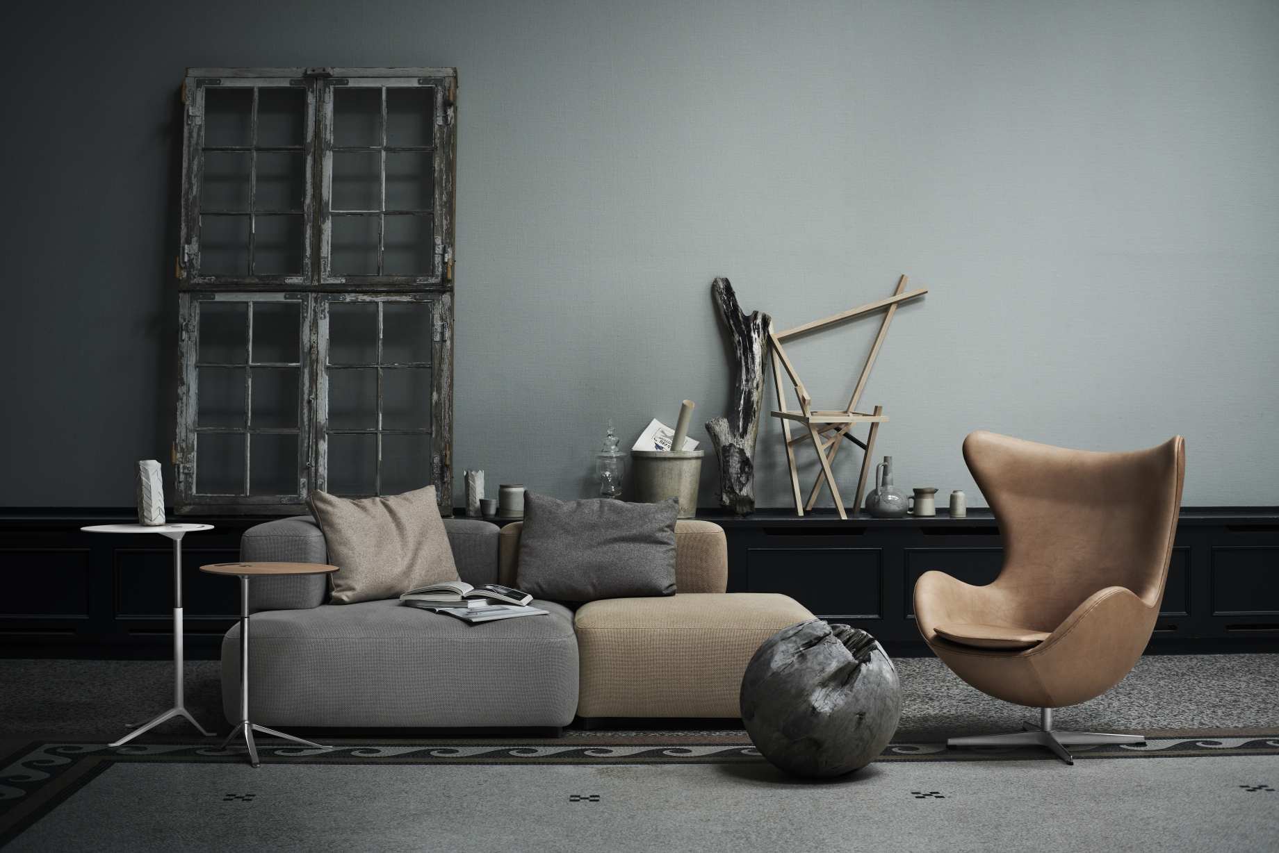 Wohnzimmer-Szene mit Fritz Hansen Little Friend Beistelltisch, Sofa und Sessel in gedämpften Farben.
