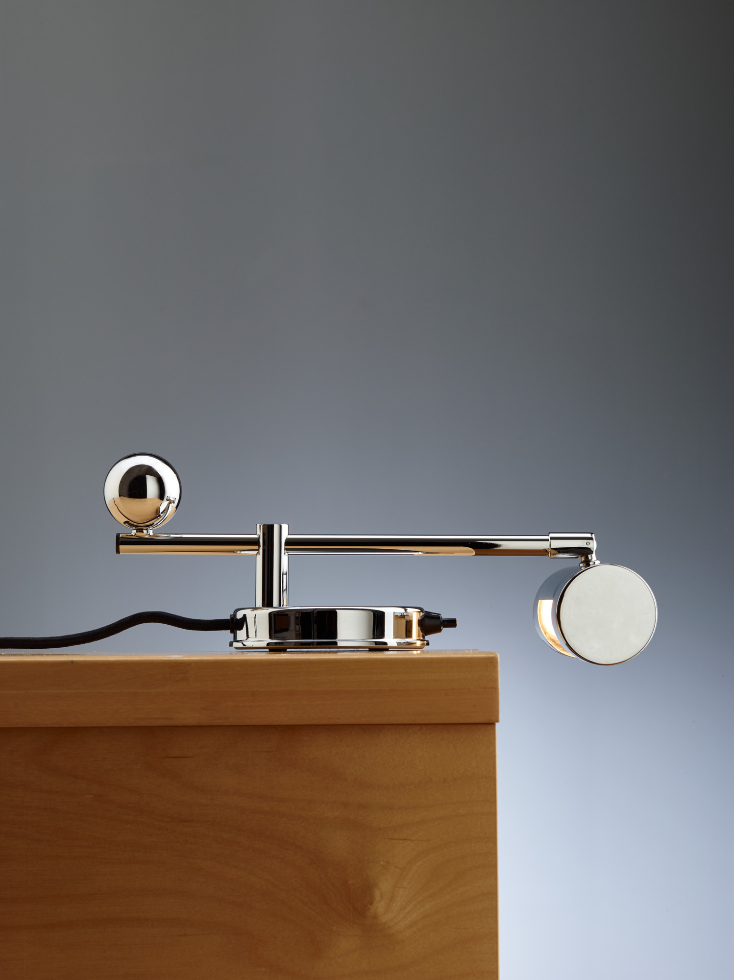 Tecnolumen DS 28 Klavierleuchte im De Stijl Design, Chrom, auf Holzoberfläche.