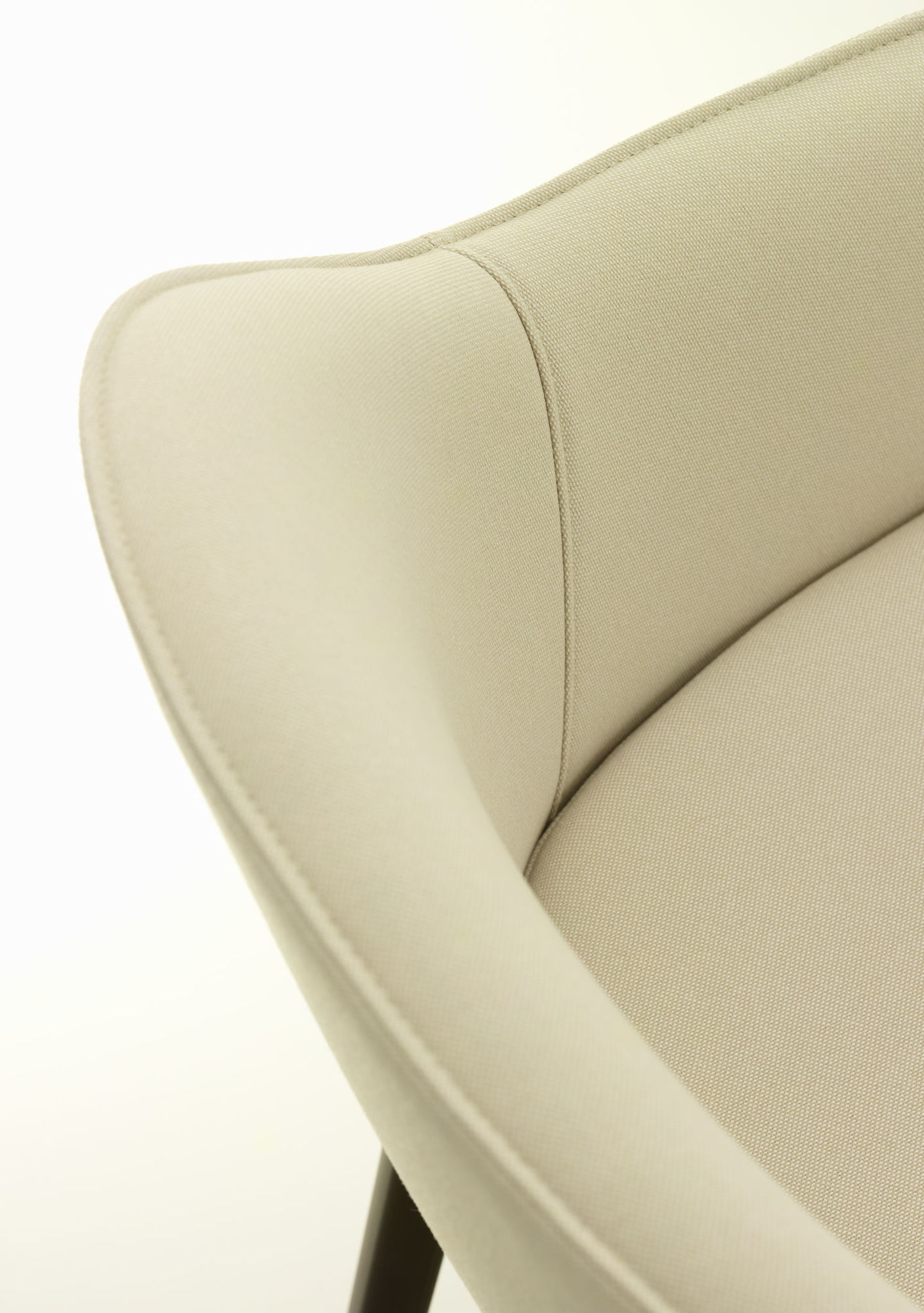Detailaufnahme des Vitra Softshell Chair mit Vierfußgestell, Bezug in hellem Stoff und eleganten Konturen.