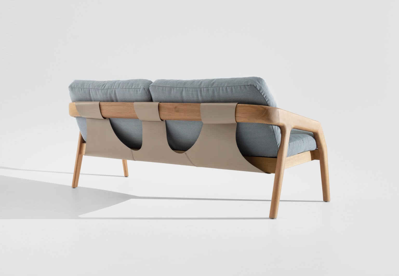 Rückansicht des Friday 2 Sofas von Zeitraum mit hellblauem Stoff und Lederdetails.