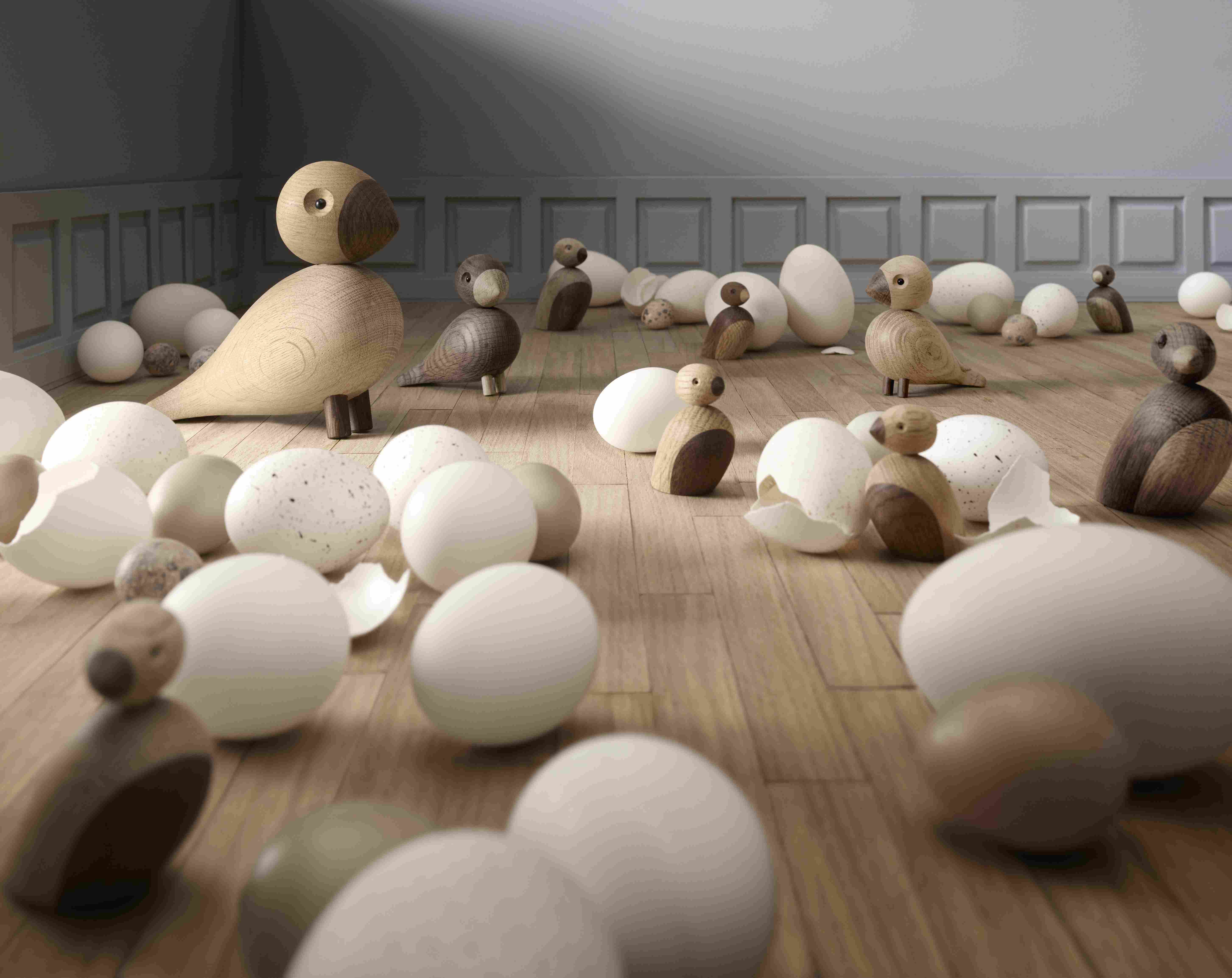 Holzfiguren Vögel und Eier auf Holzboden, skandinavisches Design, Osterdekoration, handgefertigte Holztiere für Kinder.