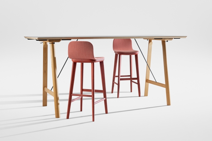 Aeon Barstool: Vollgepolsterter Barhocker in Rot vor einem Bartisch mit hellem Holzgestell.