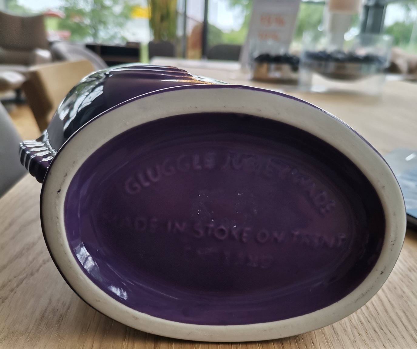 Detailaufnahme des Bodens einer lila Gluckigluck Karaffe. Keramikvase mit Herstellerangaben.