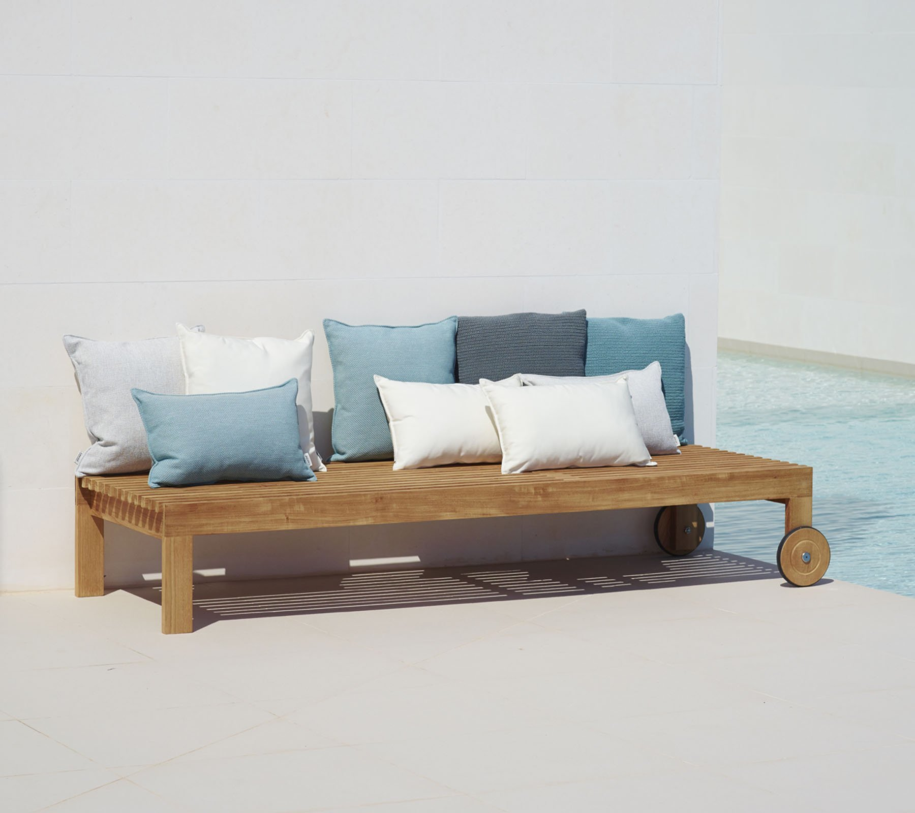 Amaze Outdoor Sonnenliege von Cane-Line aus Teakholz mit Rädern und Kissen.