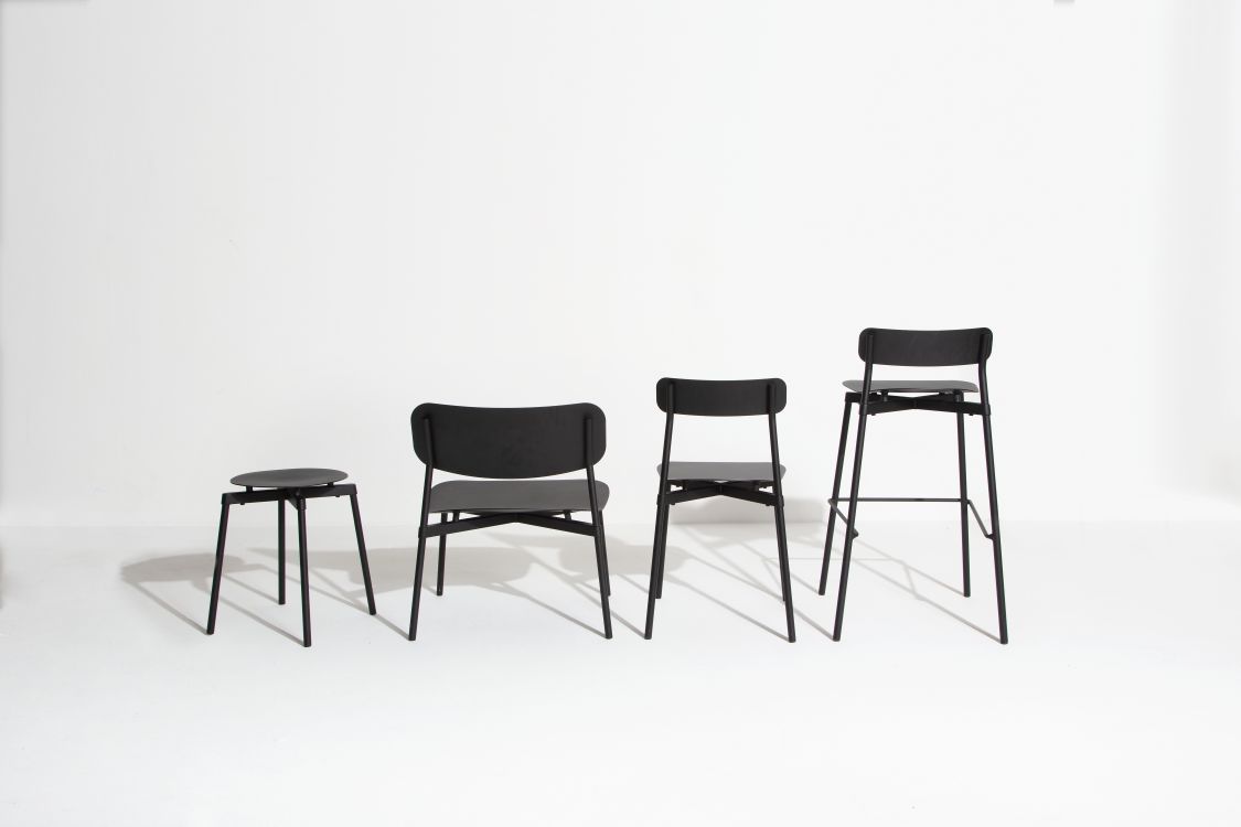 Vier schwarze Stühle und ein Hocker, darunter der Fromme Lounge Chair von Petite Friture.