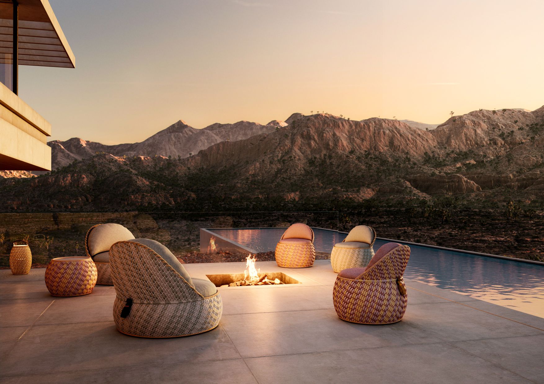 Dala Laterne von Dedon neben Outdoor-Möbeln und Feuerstelle auf einer Terrasse mit Bergblick.