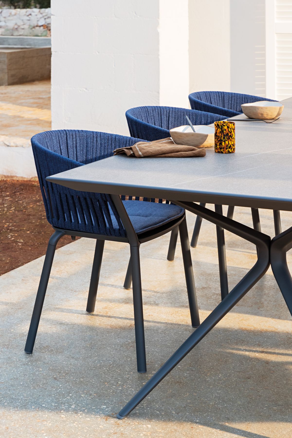 Nahaufnahme des Ria Stuhls von Fast, ein blauer Outdoor-Stuhl mit modernem Design und Sitzkissen.