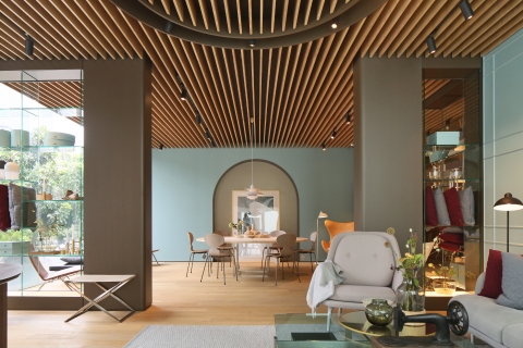 Heller Raum mit PK91 Falthocker von Fritz Hansen, Tisch, Stühlen und Designermöbeln.