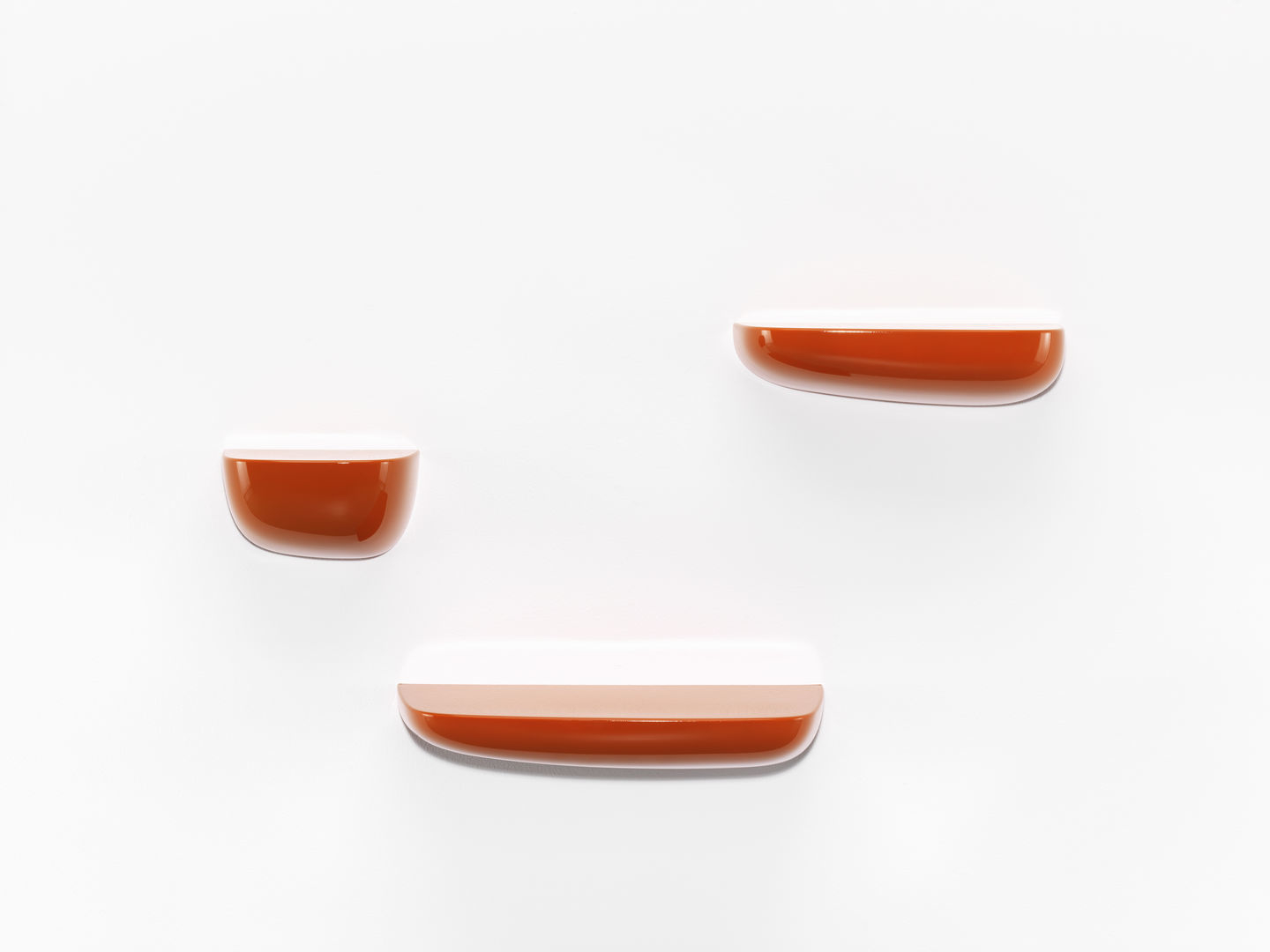 Vitra Corniches Wandboard Small, orangefarbene Design Wandregale in verschiedenen Größen an einer weißen Wand.
