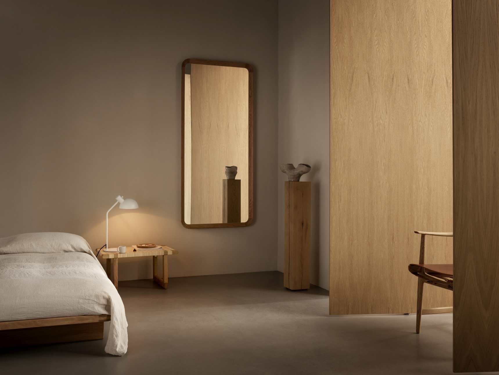 VLA62 Radio House Spiegel von Carl Hansen & Søn im Schlafzimmer mit Bett und Lampe.