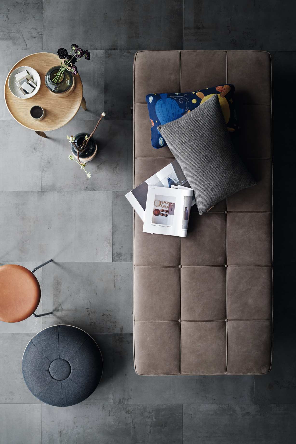 Draufsicht: Elegante PK80 Liege von Fritz Hansen, braunes Leder, Kissen, Zeitschriften und Beistelltisch.