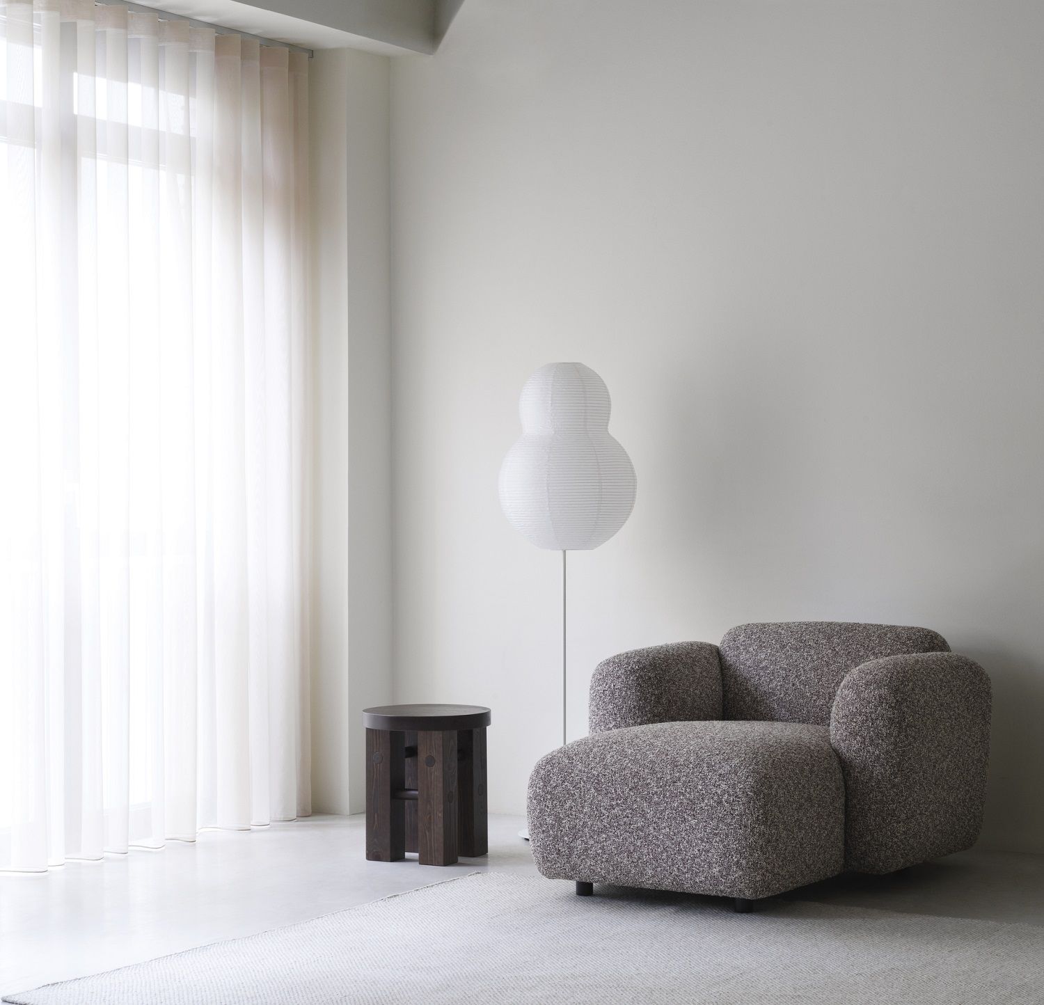 Fyr Stool Hocker von Normann Copenhagen aus dunklem Holz im minimalistischen Wohnzimmer.