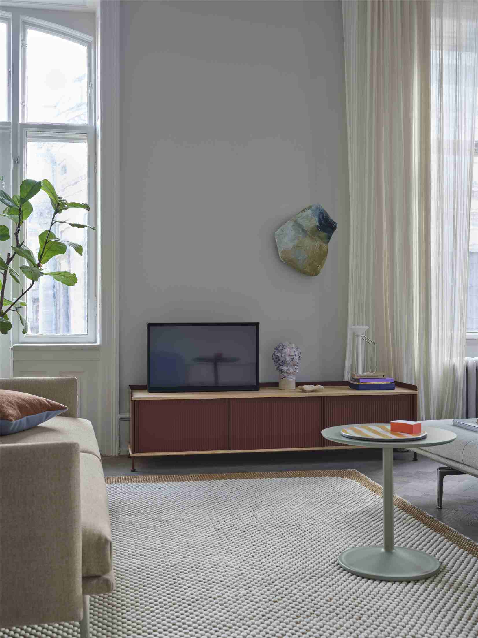 Wohnzimmer mit Sofa und Muuto Mingle Cushion Kissen in Braun- und Blautönen für moderne Wohnraumgestaltung.