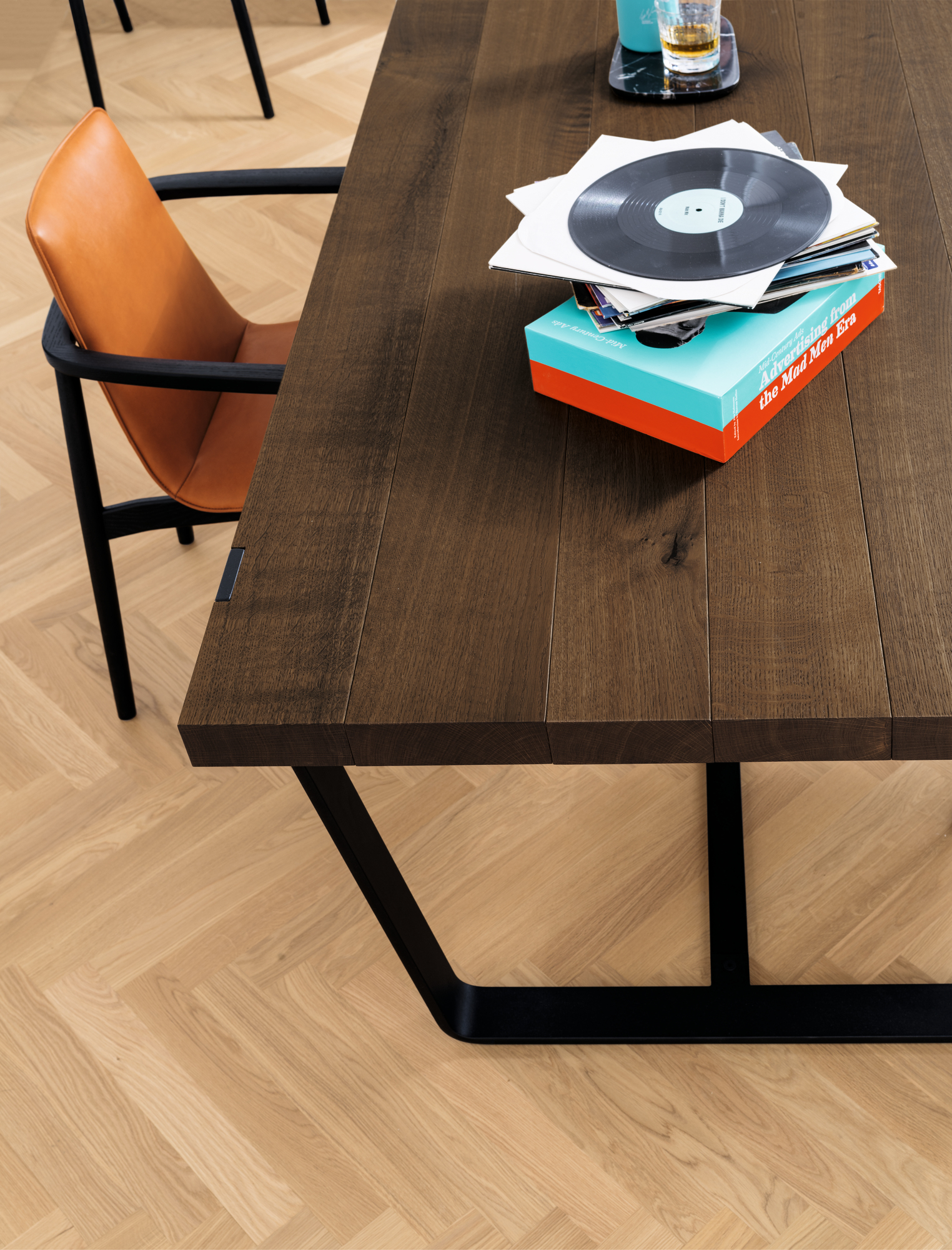 Detailaufnahme vom Janua BB 11 Clamp Tisch mit Nussbaumplatte und schwarzem Stahlgestell, dekoriert mit Schallplatten.