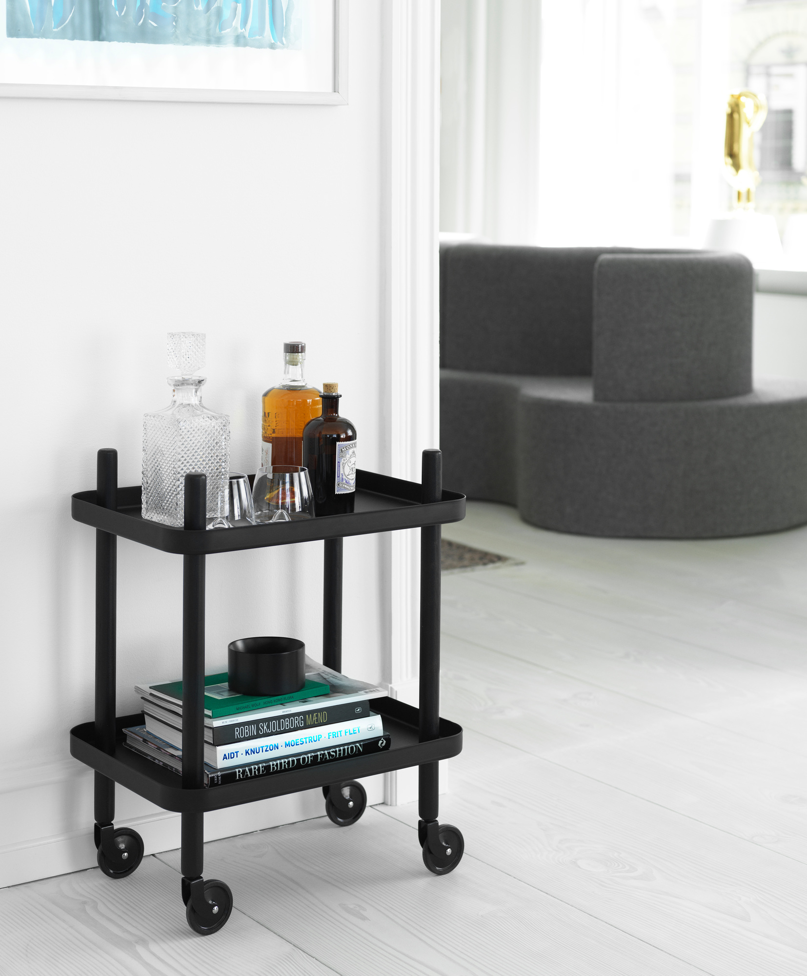 Schwarzer Block Table Servierwagen von Normann Copenhagen mit Getränken und Büchern im modernen Interieur.