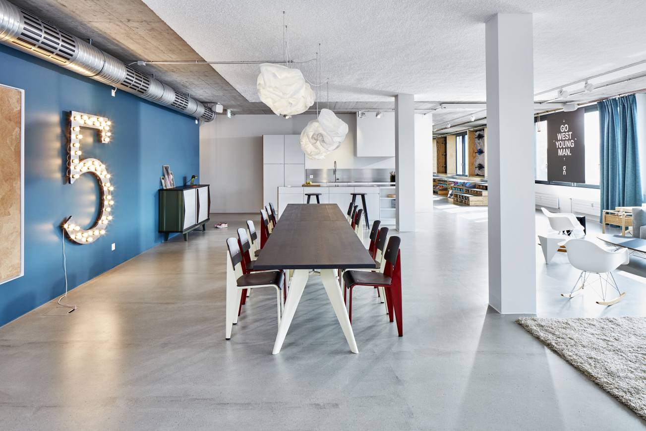Großzügiger Raum mit langem, dunklem EM Table Tisch Holz B 90 x L 260 cm von Vitra.