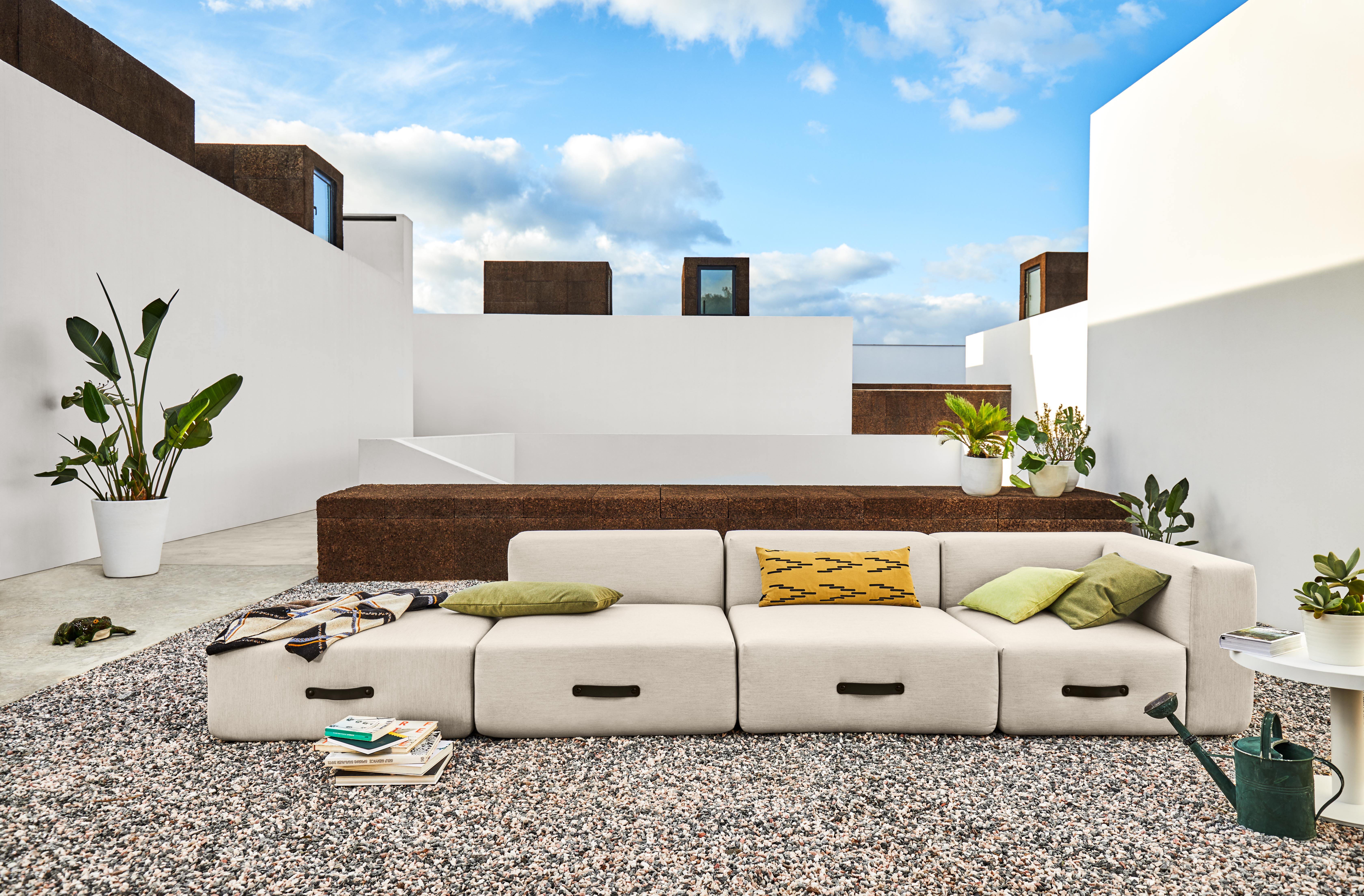 Miami Outdoor Sofa mit anthrazitfarbenen Wurfkissen von Conmoto auf einer Dachterrasse. Gartenmöbel für den Außenbereich.