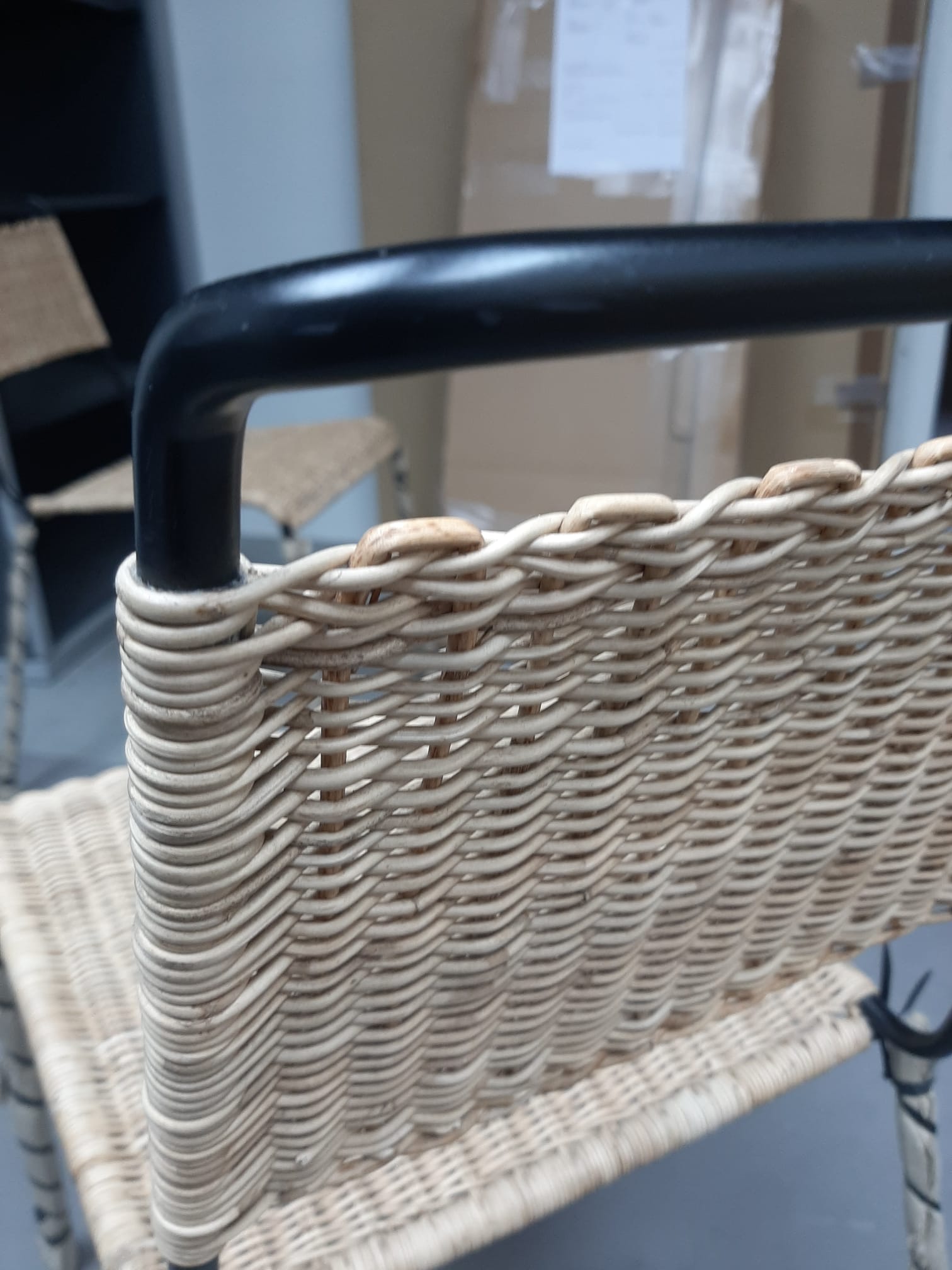 Detailaufnahme des Stuhls TT 54 von Richard Lampert, ein Rattanstuhl mit schwarzem Metallgestell, Mängelexemplar.