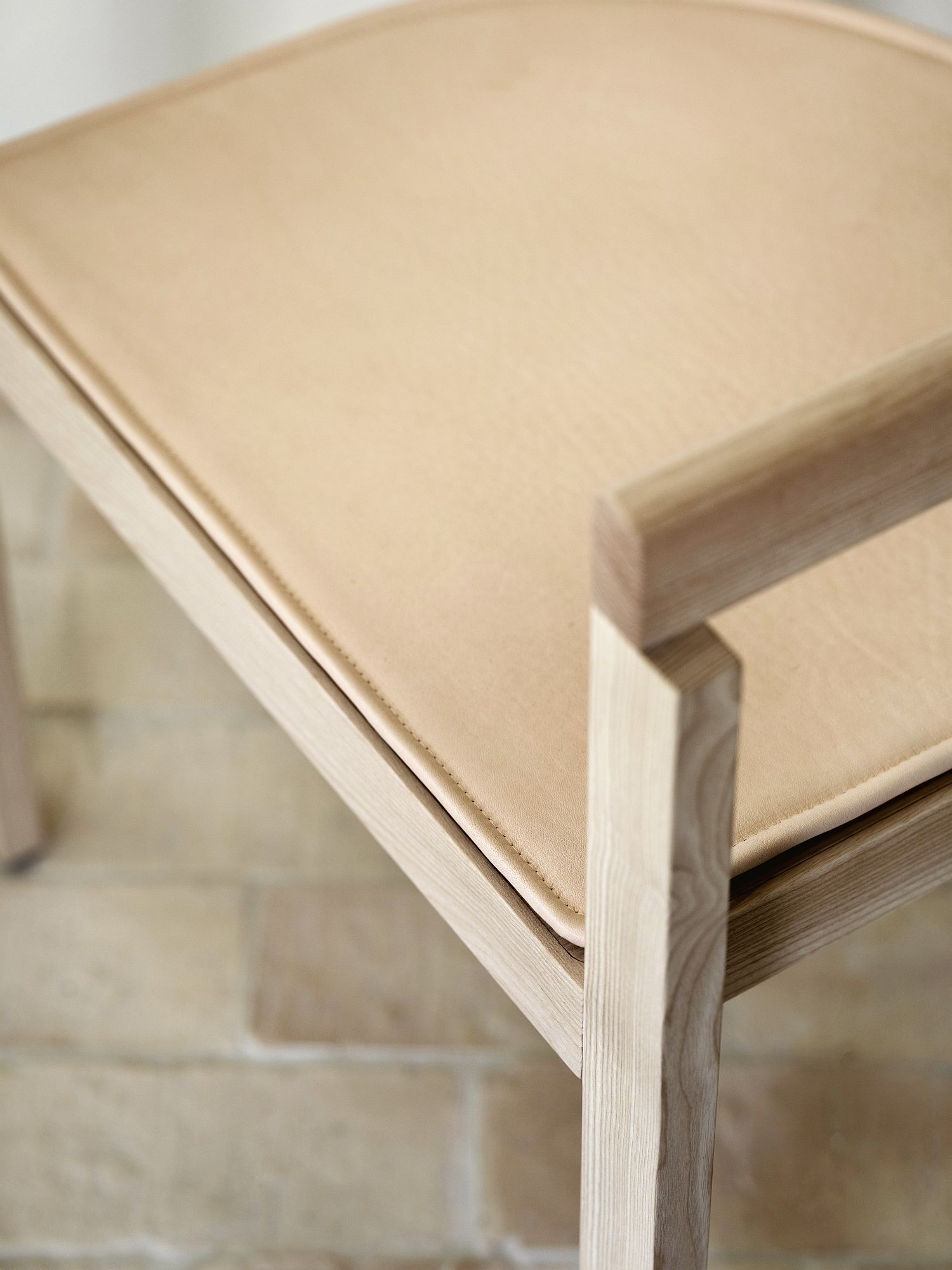 Detailaufnahme der After Sitzauflage für Fritz Hansen Dining Chair Stuhl mit hellem Holzrahmen und Lederbezug.