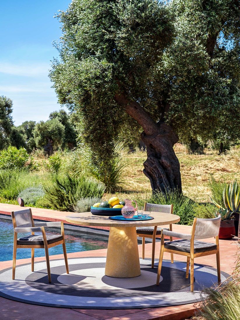 Cassina Dine Out Esstisch mit Terrazzo-Platte in Weiß-Gelb im Outdoor-Bereich mit Pool.