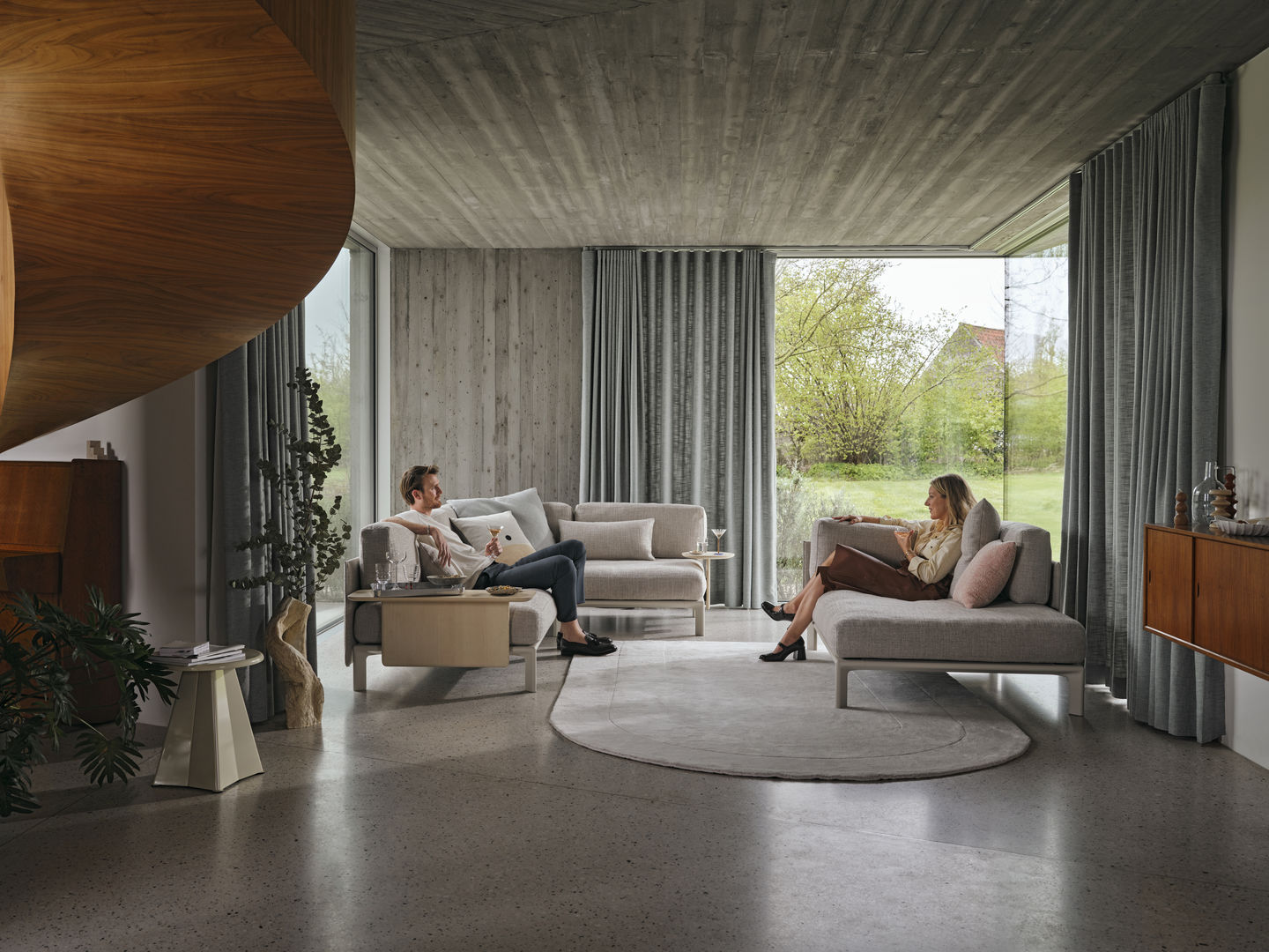 Helles Wohnzimmer mit Vitra Anagram Sofa Plattform, zwei Personen entspannen auf der Couch.